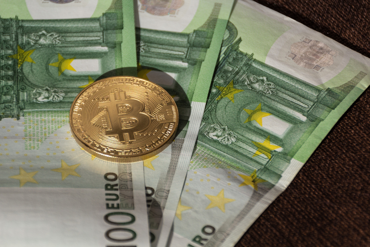 Kryptowährung Bitcoin Münze mit hundert Euro Scheinen
